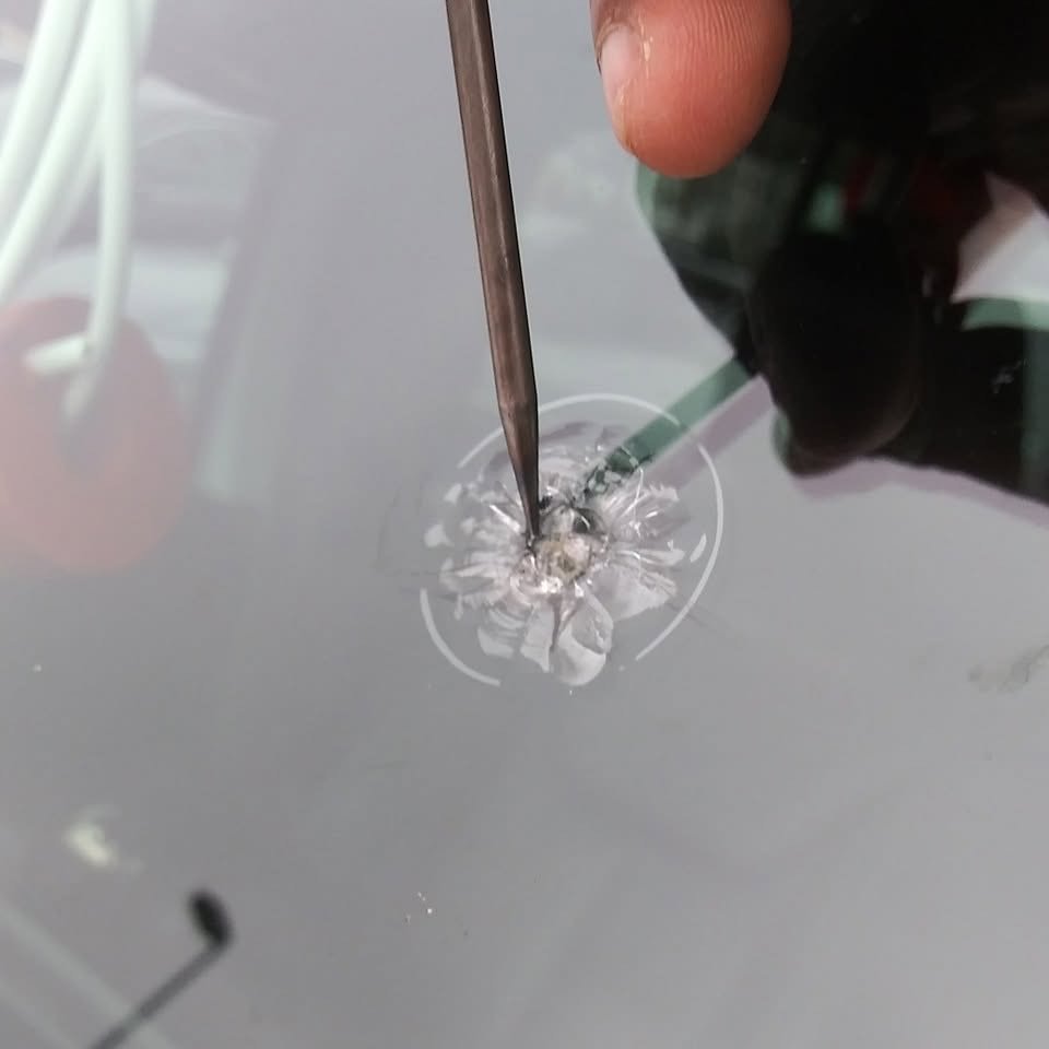 Technician working resin into a windshield rock chip in Pharr, Texas